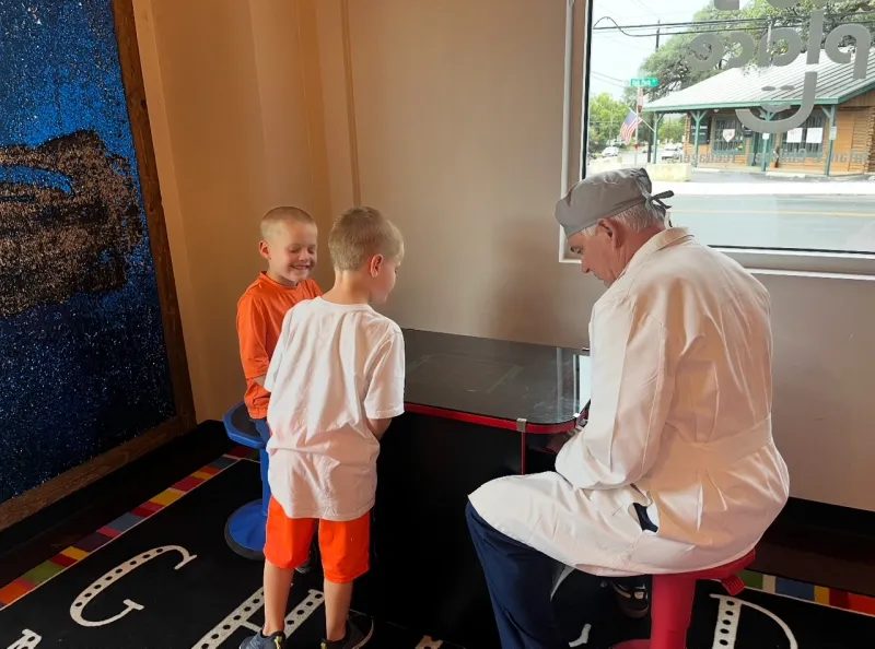 Dr. Wilkerson playing arcade games with two young patients at The Kid’s Place in Boerne, TX