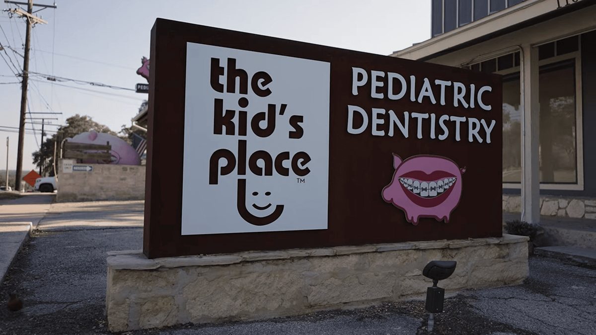 The Kid’s Place Pediatric Dentistry sign with pig mascot at 1101 S Main St in Boerne, TX