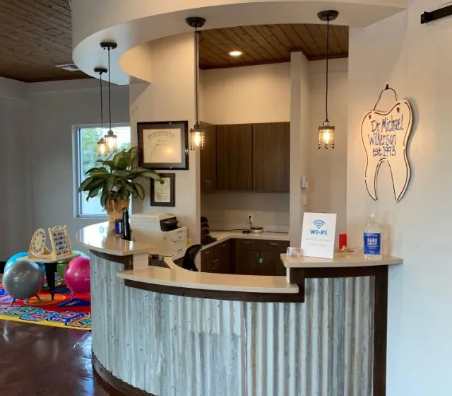 Front desk and colorful kids play area at The Kid’s Place pediatric dentistry in Boerne, TX