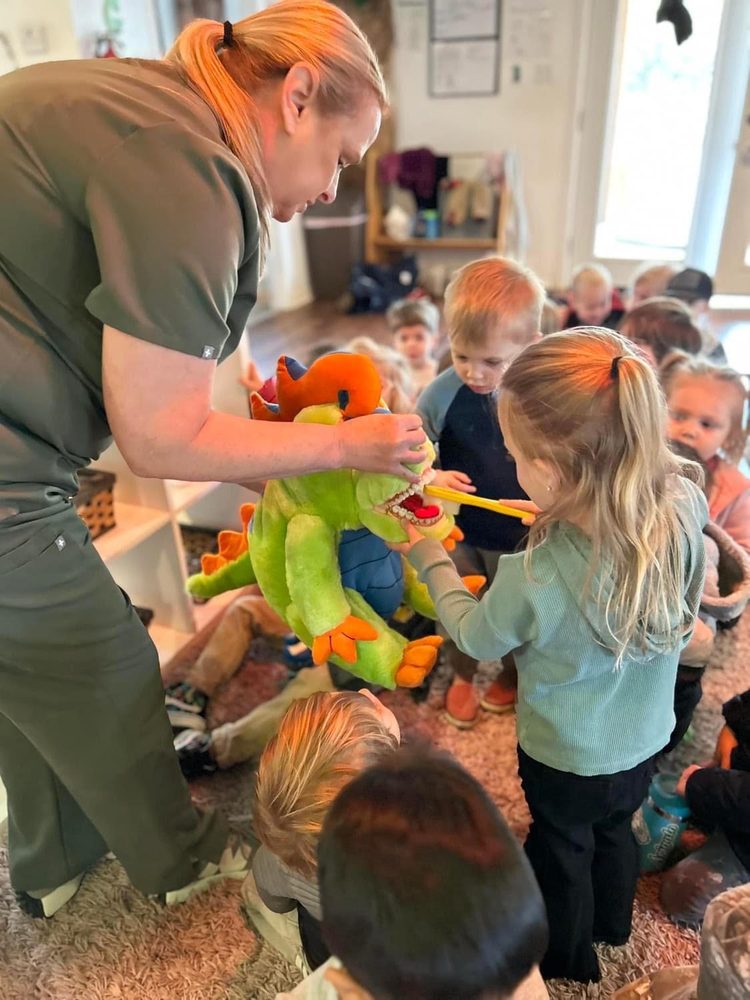 Preschooler practicing brushing on The Kid's Place dragon puppet