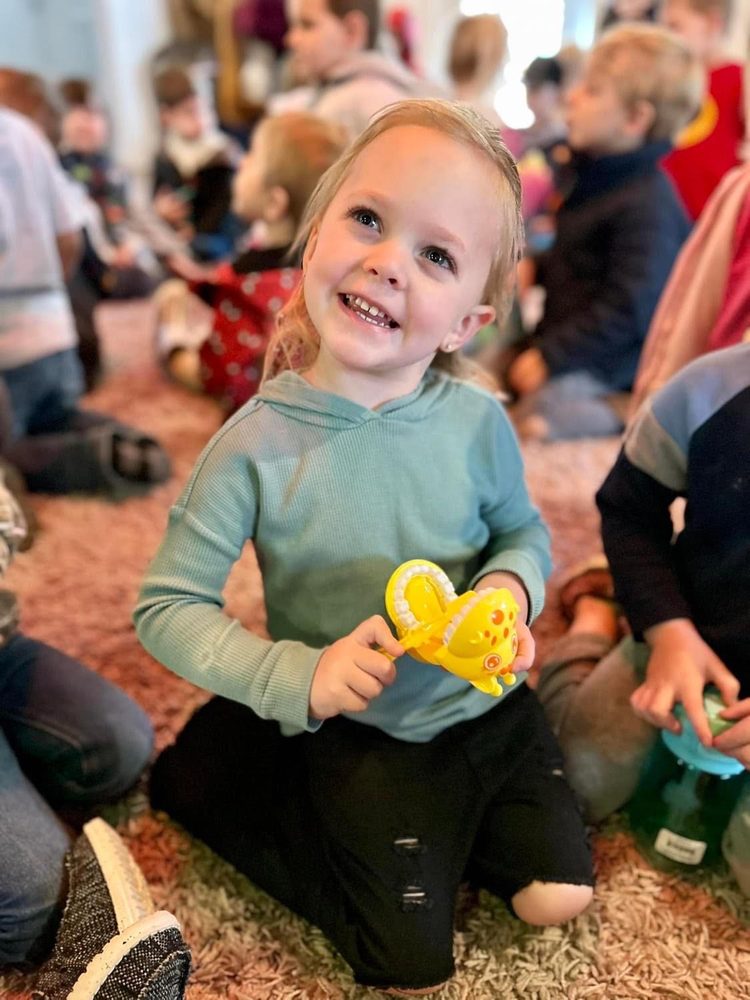 Smiling preschooler holding a toy set of teeth